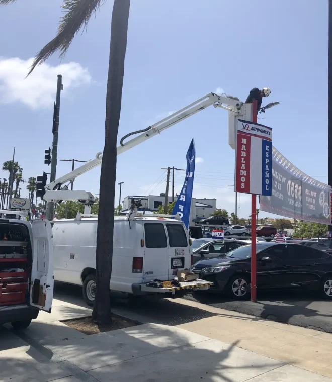 Tamar Electric bucket truck lifting an electrician up to repair a tall business sign in Escondido