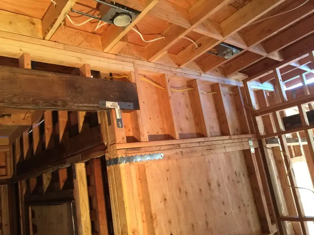 New electrical wiring run through open wall framing during a remodel by Tamar Electric